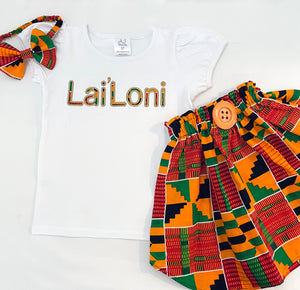 Girls' vibrant kente fabric skirt set with a personalized embroidered t-shirt and a matching headband